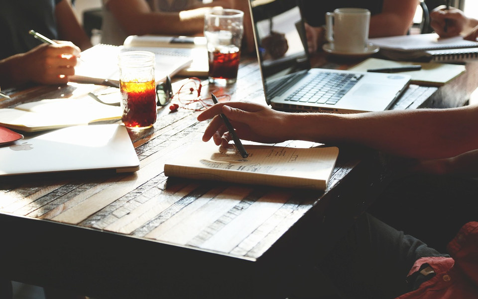 A team working together around a table with laptops and notebooks